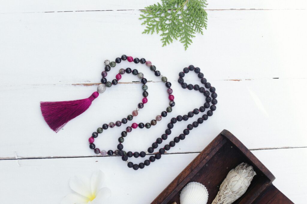 Elegant mala beads and decorative elements on a rustic table setting.