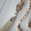Beautifully crafted beaded necklace with tassel, featuring gemstones and a unique design.