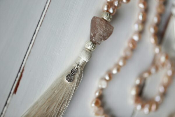 Beautifully crafted beaded necklace with tassel, featuring gemstones and a unique design.